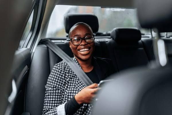 VIP passenger smiling in back seat during chauffeur service